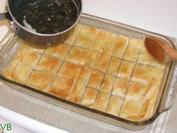 Se toarna siropul fierbinte peste baclavaua calda.